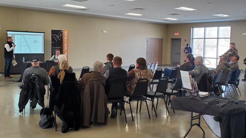 Group of professionals gathered in a meeting room discussing strategy and reviewing information together.
