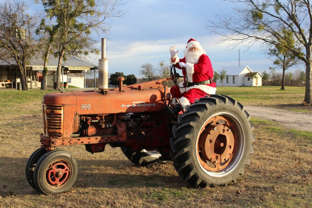 Santa Claus riding a vintage tractor on an Iowa farm during the winter season