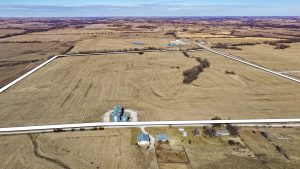 Aerial view of Ringgold County, IA land for sale—Tract 2 (197.51± acres) with the boundary outlined in white, showing open farmland and grain bin storage along the road.