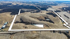 Aerial view of Ringgold County, IA land for sale—Tract 7 (113.67± acres) with the boundary outlined in white, showing rolling tillable acres, timbered draws, and multiple ponds for recreation.