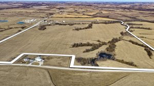 Aerial view of Ringgold County, IA farmland for sale—Tract 4 (212± acres) with 161.39± tillable acres, showing the boundary outlined in white, rolling cropland, timbered draws, and a pond.