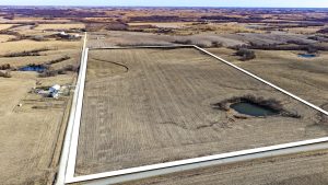 Aerial view of Ringgold County, IA farmland for sale—Tract 6 (80± acres) of premium tillable land with the boundary outlined in white, showing a large open field with a pond and road frontage.