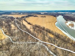 Aerial view of Polk County, Iowa farmland bordered by a river, with the property boundary outlined in white.