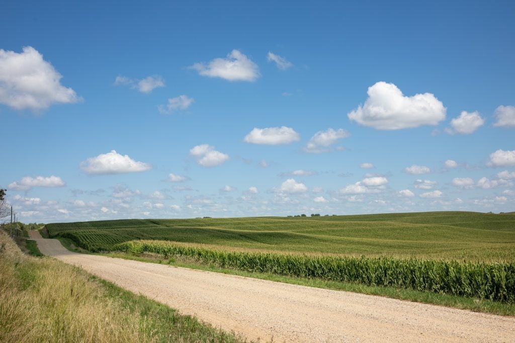 iowa farmland landscape with rural road representing land auction broker services