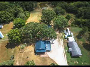Aerial view of Crawford County Missouri farmhouse for sale in Steelville with private pond and 3 acres