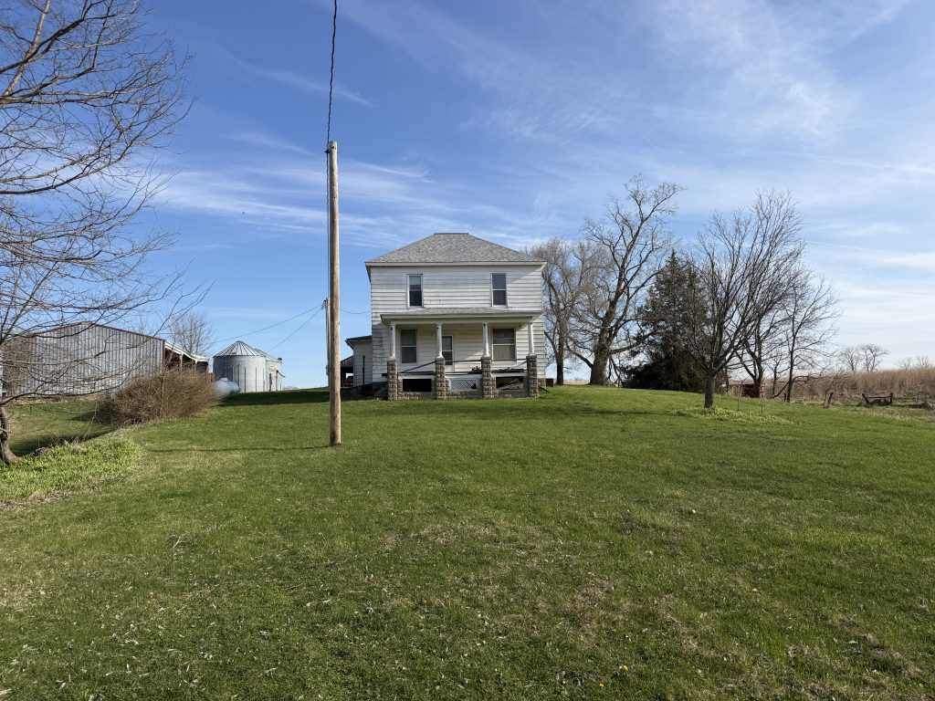 Louisa County Iowa land auction farmhouse with grain bins and outbuildings on rural acreage near Ainsworth Iowa