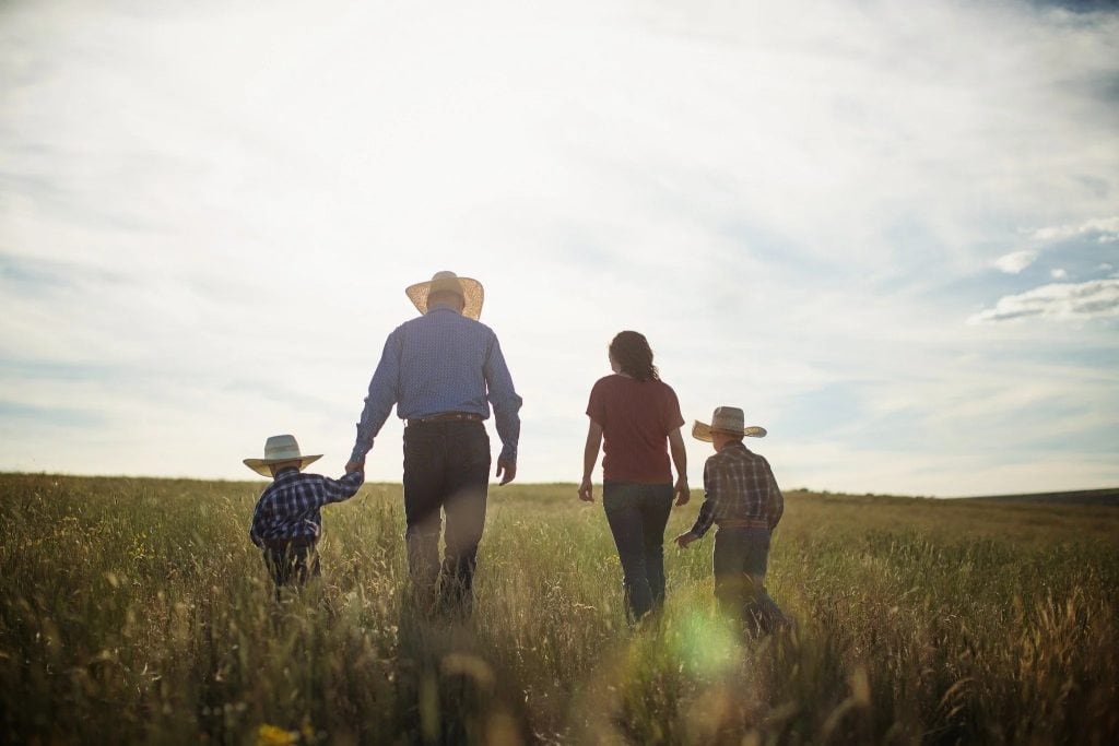 Family walking through inherited farmland in the Midwest