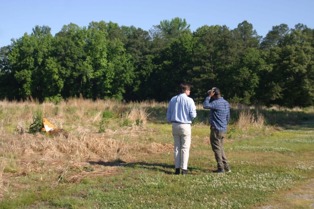 Buyers inspecting rural acreage property before purchasing land in Iowa