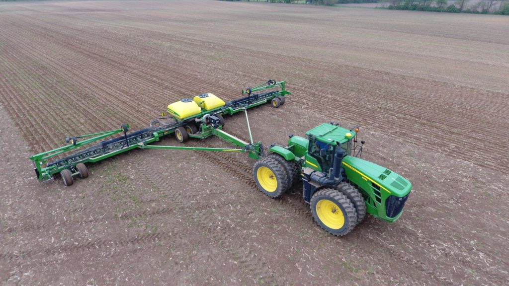 Large modern farm equipment operating on productive Iowa farmland