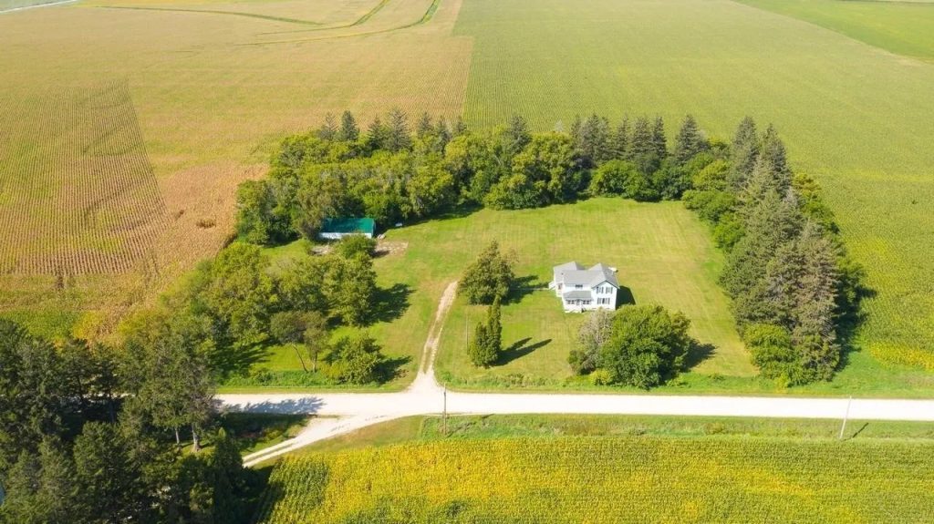 Iowa country acreage with home, outbuildings, and farmland surroundings
