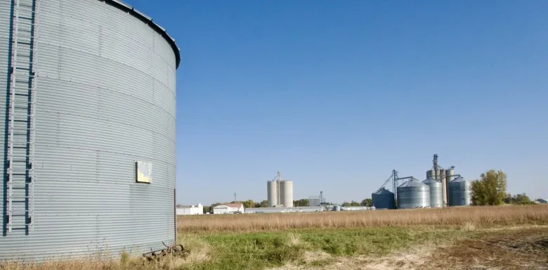 Grain bins and farm infrastructure on a well-maintained rural property, highlighting features that make farmland more attractive to buyers.