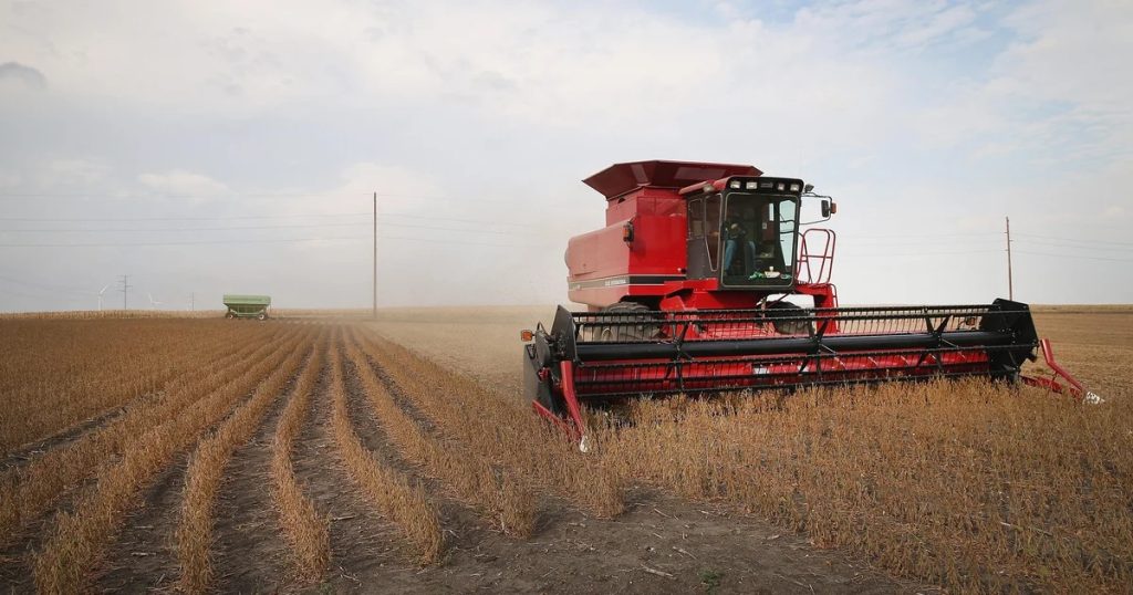 Combine harvesting soybeans on a family farm, highlighting the importance of fair and equitable farm succession planning to preserve agricultural operations for future generations.