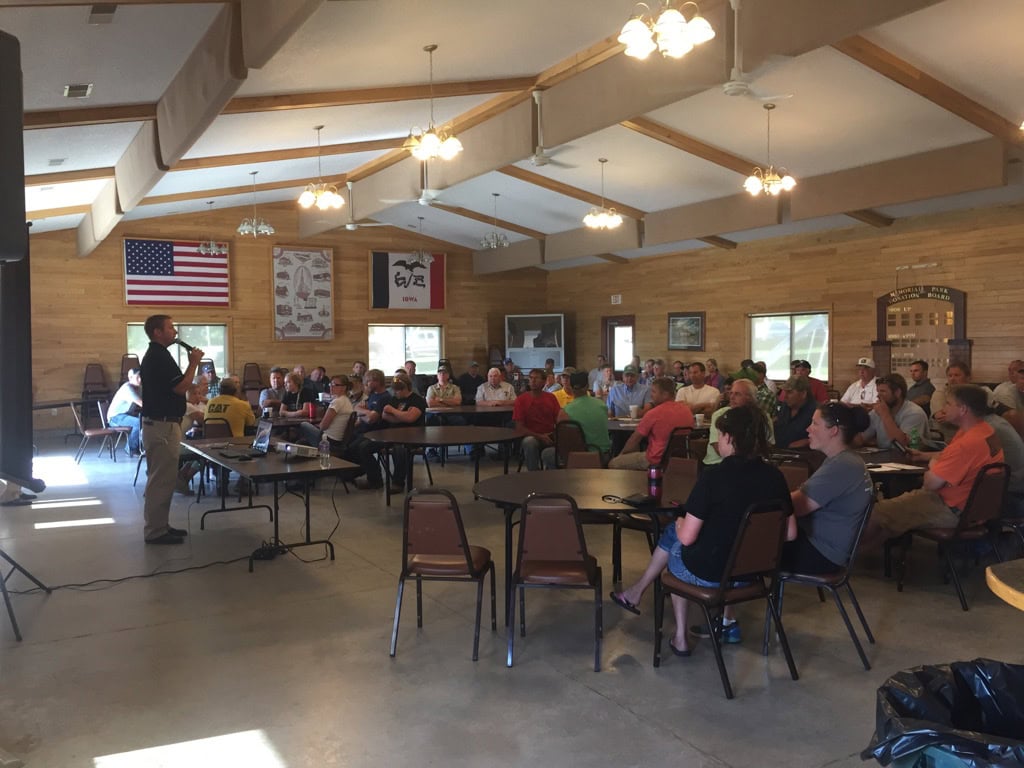 Crowd attending a live farmland auction and land sale event with buyers bidding on agricultural real estate.
