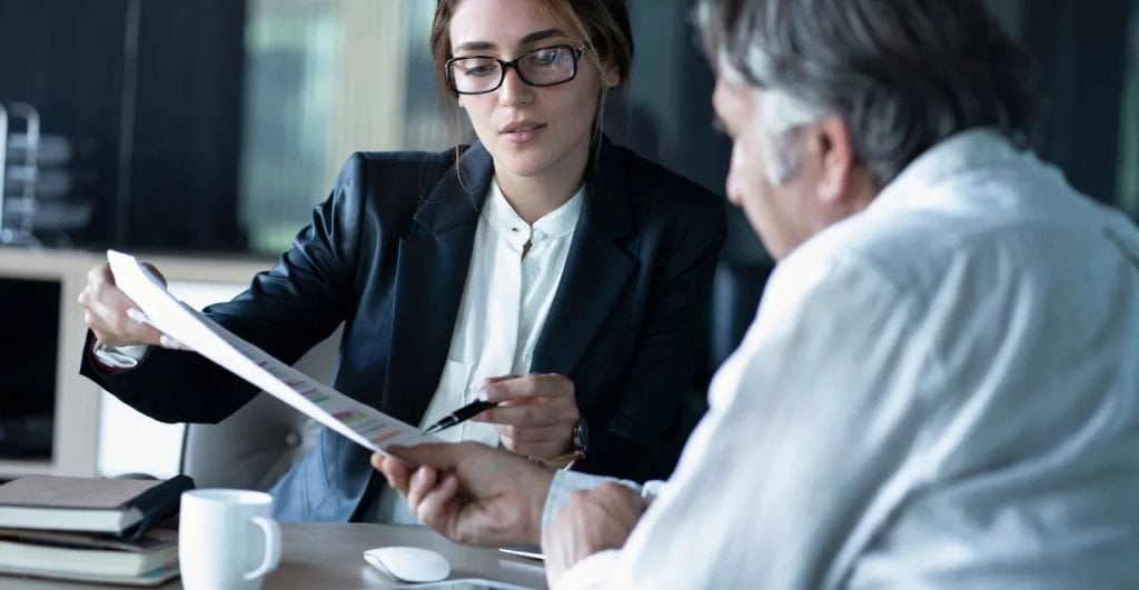 Landowner reviewing a land purchase offer with a real estate professional to determine fair market value and negotiate the best terms.